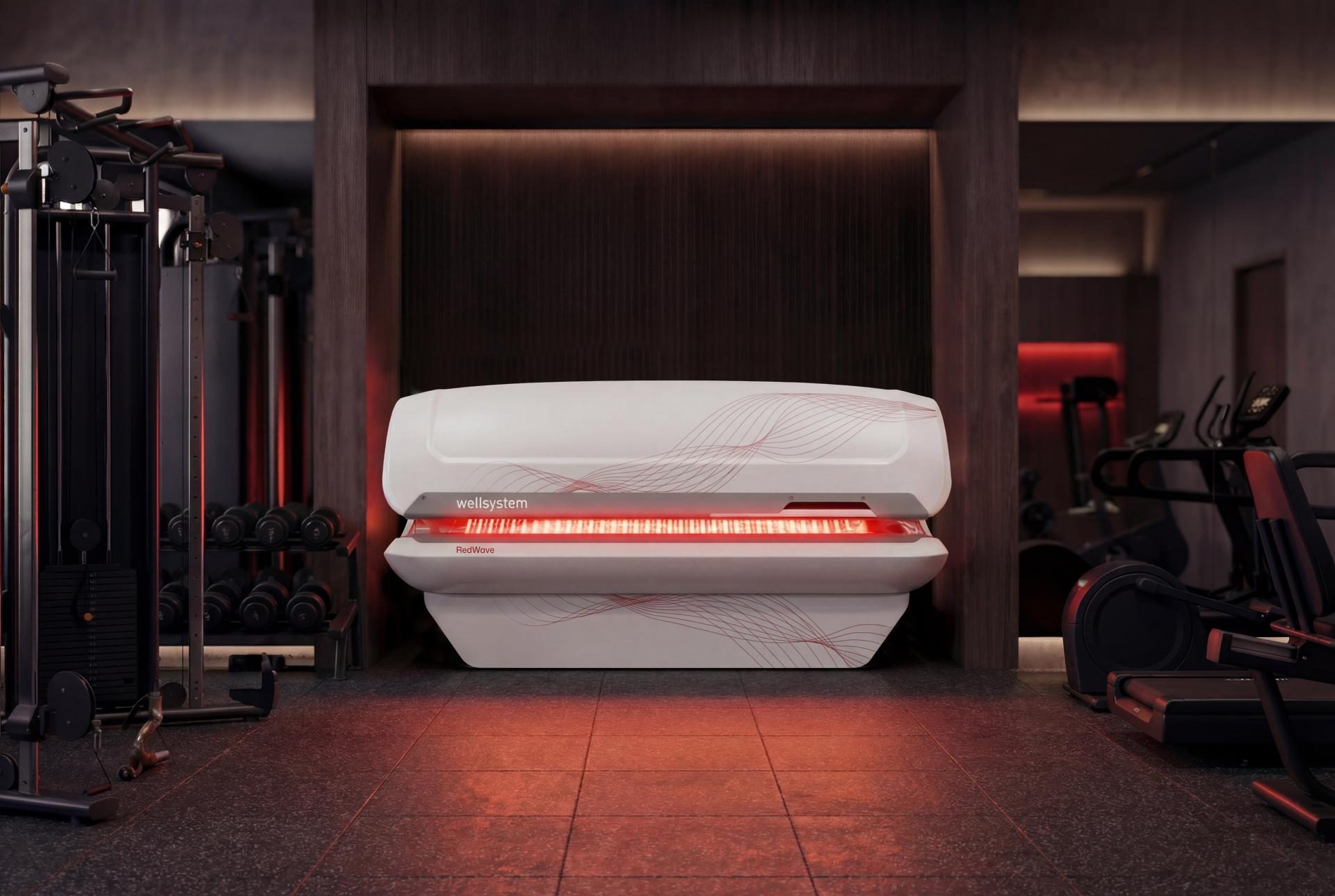 White RedWave Plus bed with red wave graphics in a premium gym