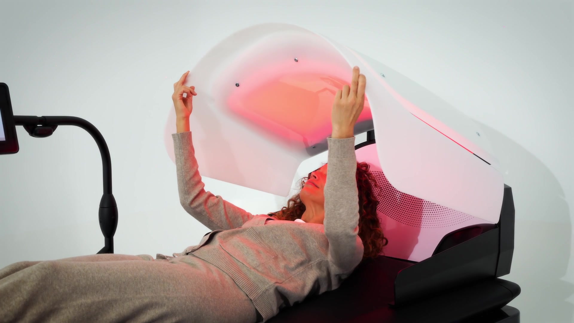 A guest relaxing under the HydroWave spa hood with warm light